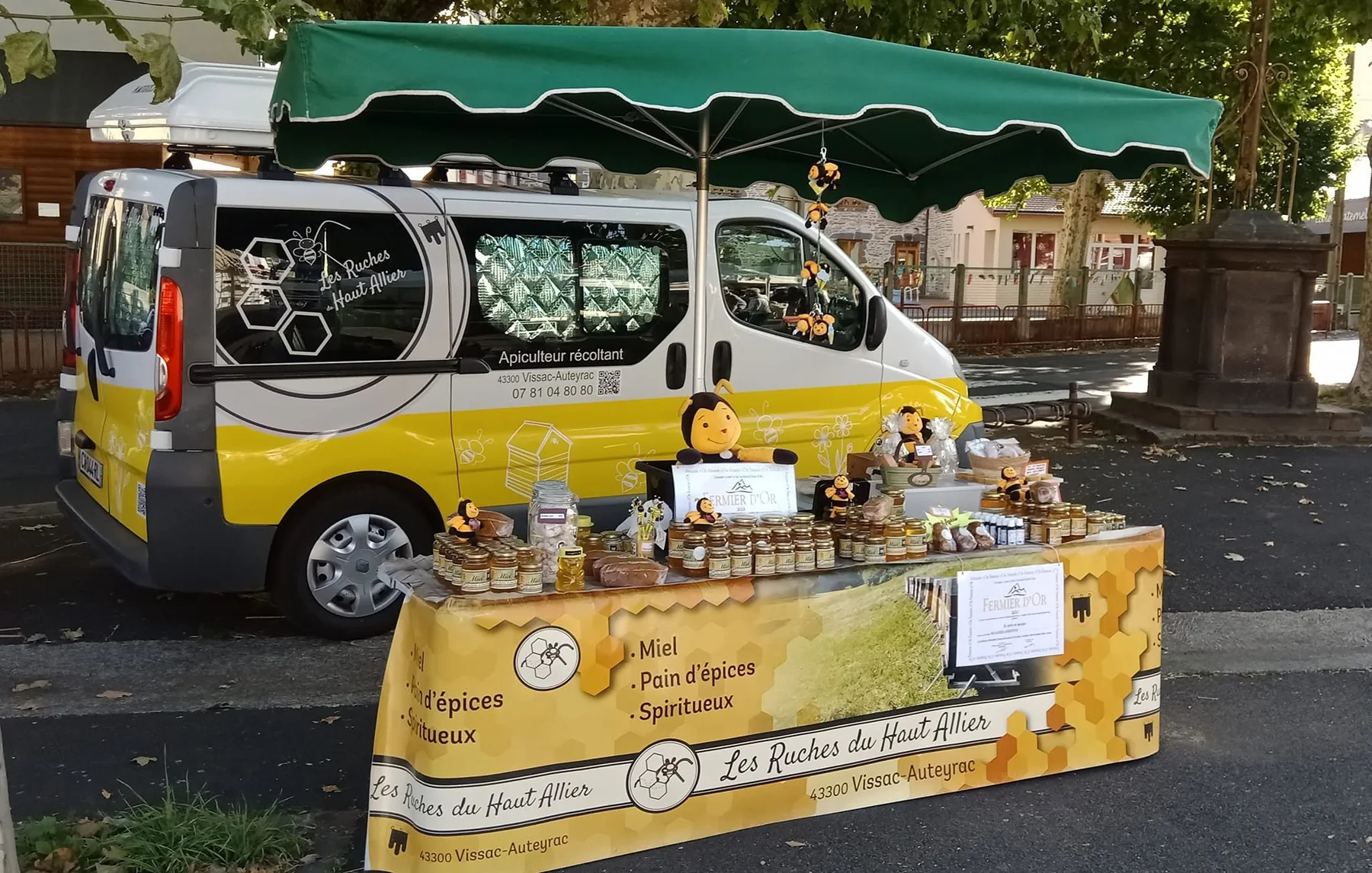 Stand des Ruches du Haut-Allier sur un marché avec le véhicule de l'exploitation